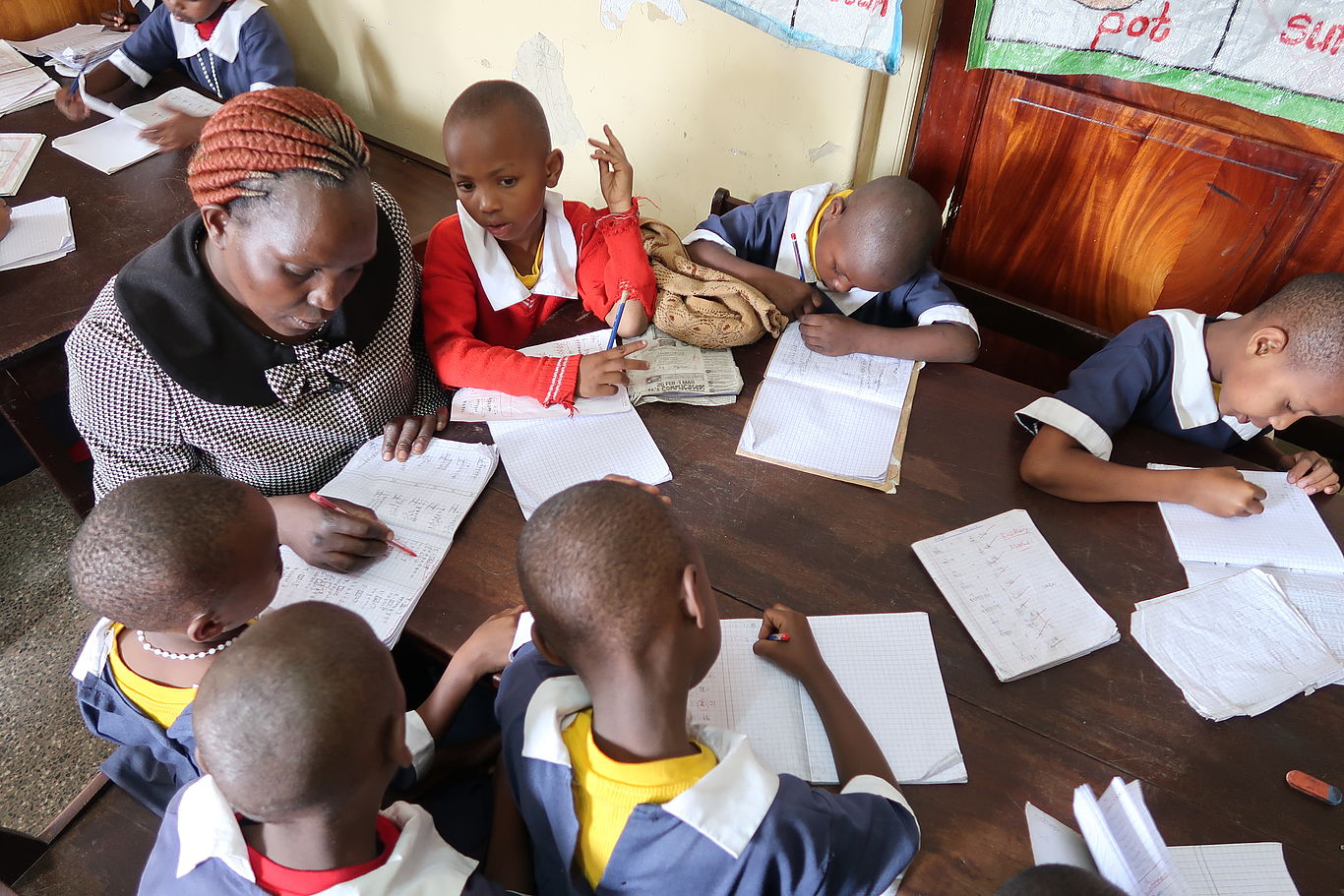 Kenia: Schutz für Mädchen/Foto: Seidl Eine Lehrerin sitzt mit einigen Mädchen rund um einen Tisch und unterrichtet sie.